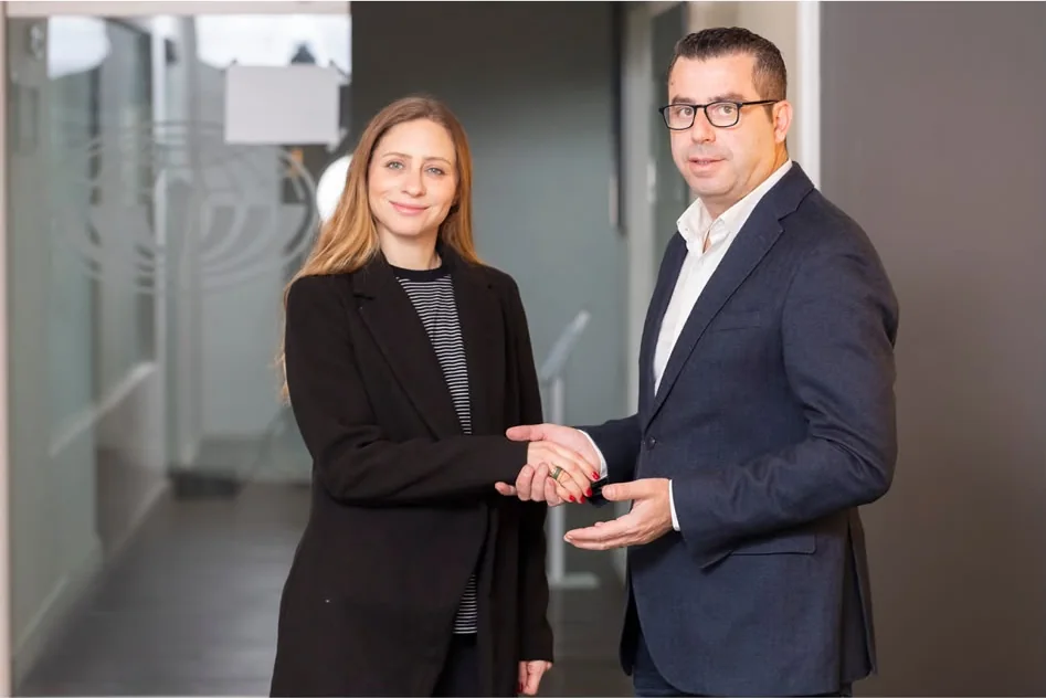 Two business partners shaking hands in a modern office